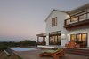 Modern home with Gardens, Wood Tread, Large Patio, Porch, Deck, Closet Storage Type, Wood Patio, Porch, Deck, Under Stairs Storage Type, Metal Railing, Pendant Lighting, Medium Hardwood Floor, Wood Burning Fireplace, Picture Window Type, Wood, Bench, Engineered Quartz Counter, Freestanding Tub, Open Shower, Recessed Lighting, Stone Tile Wall, Back Yard, and Infinity Pools, Tubs, Shower. Dusk from the Infinity Pool Photo 13 of Modern Vineyard Farmhouse