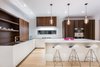 The Boffi kitchen features Corian cabinet fronts, acacia wood units and hood vent, stainless countertop, and a white matte lacquer island with a Corian counter top. Photo 6 of Manor Road house modern home