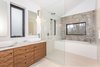A master ensuite, with a bath/shower area, Vestige pattern tiles from Aparici, marble countertop and a walnut vanity. Photo 9 of Manor Road house modern home
