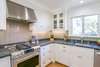 Modern home with Kitchen, White Cabinet, Glass Tile Backsplashe, Granite Counter, Medium Hardwood Floor, Recessed Lighting, Ceiling Lighting, Cooktops, Range, Range Hood, Dishwasher, and Undermount Sink. White Farmhouse Kitchen Remodel Photo 3 of White Farmhouse Kitchen Remodel