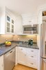 Modern home with Kitchen, Granite Counter, White Cabinet, Medium Hardwood Floor, Ceiling Lighting, Recessed Lighting, Glass Tile Backsplashe, Microwave, Dishwasher, and Undermount Sink. White Farmhouse Kitchen Remodel Photo 4 of White Farmhouse Kitchen Remodel