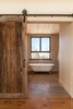 Main bathroom has a very warm feeling created by the raw elements used on the floors, walls and ceiling. Photo 6 of La Maison Hatley modern home