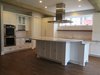 Modern home with Kitchen, Subway Tile Backsplashe, White Cabinet, Medium Hardwood Floor, Granite Counter, Ceiling Lighting, Microwave, Wall Oven, Cooktops, Recessed Lighting, and Undermount Sink. The open kitchen is perfect for entertaining. The curved island was designed to maximize lines of sight for anyone seated around the island. Photo 4 of Commercial Garage Converted