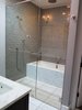 The lovely master bathroom features a combined soaking tub and expansive shower behind frameless glass. Photo 8 of Commercial Garage Converted modern home