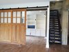Modern home with Living Room, Ceiling Lighting, Recessed Lighting, Accent Lighting, and Medium Hardwood Floor. Concrete support beams were trained as part of the design scheme. Sliding barn doors were custom built to separate the study from the family room. Photo 13 of Commercial Garage Converted