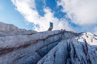 Designed by OFIS Arhitekti, the Kanin Winter Cabin is a compact wooden volume with three platforms extending out over the valley. A large, glazed panoramic window provides breathtaking views of the surrounding Kanin Mountains.