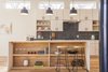 Modern home with Kitchen, Wood Cabinet, Engineered Quartz Counter, Dishwasher, Concrete Backsplashe, Refrigerator, Open Cabinet, Microwave, Light Hardwood Floor, White Cabinet, Undermount Sink, and Pendant Lighting. This is the Unit A Kitchen - a fun mix of warm colors and textures. 10/10 would buy :) Photo of The Reyes Duplex
