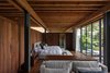 Modern home with Bedroom, Ceiling Lighting, Dark Hardwood Floor, Bench, and Night Stands. The intimacy of Casa Santísimo is exemplified in the bedroom—JJRR Arquitectura installed warm wood walls to contrast with the serene forest views. Photo 4 of Santísimo House