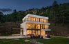 Modern home with Outdoor, Side Yard, Front Yard, Shrubs, Grass, Trees, Hardscapes, Boulders, Large Patio, Porch, Deck, Metal Patio, Porch, Deck, Concrete Patio, Porch, Deck, Wood Patio, Porch, Deck, and Landscape Lighting. Main House Evening Photo of The Tesla of Boulder Homes Offered at $3,950,000