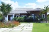 Modern home with Outdoor, Front Yard, Grass, Shrubs, Garden, Trees, Walkways, Gardens, Flowers, Landscape Lighting, and Horizontal Fences, Wall. Exterior View Photo of Bahamian Retreat