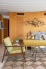 Modern home with Living Room, Sofa, Bench, Chair, End Tables, Ceramic Tile Floor, and Coffee Tables. The Sarasota Architectural Foundation recently signed a long-term rental for the house and it has been given new life. Refurbished in 2018, the Cocoon House delights with a refinished exterior and vintage-inspired interior. Through teamwork and considerate design work, Ellen Hanson Designs, Pansy Bayou and the Sarasota Architectural Foundation were able to envision a millennial update to this 1950s historical home. Photo 5 of The Cocoon House