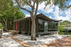 Modern home with Exterior, Curved RoofLine, and House Building Type. Set on a quiet lane in Siesta Key, this jewel box home measuring about 760 square feet, holds firmly on cantilevered beams that inch over Bayou Louise. The simple layout lends to an uncluttered coastal lifestyle. The catenary roof curves down into the interior to create an intimate space inside while exhibiting historic architectural feats from the outside. Photo of The Cocoon House