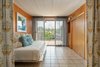 Modern home with Bedroom, Bed, Ceramic Tile Floor, and Wall Lighting. Each corner of the home is styled with thoughtful details. Simple lighting, timely furniture pieces and coastal artwork all contribute to the clean lines which complement the purity of Rudolph’s architecture. Photo 7 of The Cocoon House