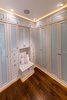 Master bedroom closet with custom cabinets, custom lighting features, and frosted glass panels to conceal the closet contents and keep everything dust free. Photo 4 of Modernized English Style modern home