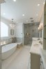 Master bath retreat with spa tub, steam shower, and his and her sinks. There is also a fireplace in the wall at the foot of the tub. Photo 8 of Modernized English Style modern home