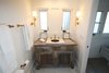 Vintage marble sink and brass lanterns complete this very special beach house getaway bathroom. Photo 3 of Streamlined Cape Cod at The Wedge modern home