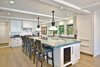 Magnificent open plan kitchen and dining room with extra large Island. Photo 9 of Streamlined Cape Cod at The Wedge modern home