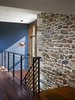 Modern home with Picture Window Type, Wood, Swing Door Type, Sliding Door Type, Exterior, Metal Tread, Metal Railing, Metal, Medium Hardwood Floor, and Hallway. A light filled, open stair hall connects the new master suite to existing second floor spaces. Photo 6 of Modern Farmhouse Addition