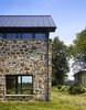 Modern home with Flowers, Trees, Front Yard, Shrubs, Picture Window Type, Metal, Casement Window Type, Wood, and Outdoor. The addition acts as a threshold from a new entry to the site beyond. Photo 4 of Modern Farmhouse Addition