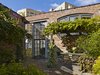 Modern home with Back Yard, Hardscapes, Shrubs, Flowers, Trees, Gardens, Large Patio, Porch, Deck, Walkways, Picture Window Type, Metal, Exterior, Swing Door Type, and Living Room. A wedge-shaped garden, enclosed within walls of an old industrial building, became the defining feature of the site. Photo 7 of Urban Garden House