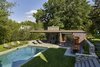 Modern home with Slope, Stone Patio, Porch, Deck, Trees, Hardscapes, Walkways, Outdoor, Large Pools, Tubs, Shower, Back Yard, Swimming Pools, Tubs, Shower, Standard Construction Pools, Tubs, Shower, and Vertical Fences, Wall. The pool house was designed to negotiate the terraced site. Photo 2 of Modern Pool House