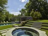 Modern home with Trees, Back Yard, Walkways, Stone Patio, Porch, Deck, Shrubs, Slope, Hardscapes, Pavers Patio, Porch, Deck, Vertical Fences, Wall, Outdoor, Large Pools, Tubs, Shower, Small Pools, Tubs, Shower, Plunge Pools, Tubs, Shower, Swimming Pools, Tubs, Shower, and Standard Construction Pools, Tubs, Shower. Stone terrace steps and hot tub. Photo 5 of Modern Pool House