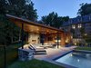 Modern home with Standard Layout Fireplace, Trees, Limestone Floor, Recliner, Wood Burning Fireplace, Back Yard, Table, Shrubs, Large Pools, Tubs, Shower, Large Patio, Porch, Deck, Chair, Vertical Fences, Wall, and Outdoor. The pool house footprint is shaped by unique site conditions. Photo 10 of Modern Pool House