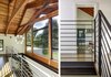 Modern home with Hallway and Medium Hardwood Floor. A second floor balcony connects bedrooms to the two-story entry foyer. Photo 15 of Wallingford Passive Solar House