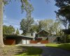 Modern home with Exterior, Glass Siding Material, House Building Type, Wood Siding Material, Metal Roof Material, Stone Siding Material, Flat RoofLine, Gable RoofLine, and Shed RoofLine. Spaces within the home’s four main volumes are designed to provide both separation and connection. The largest volume contains open kitchen, dining, and living areas, along with a master suite on the second floor, all oriented toward large south-facing windows. A single-story volume, accessible through the entry foyer, contains a home office and guest suite. A slender volume on the north side of the house contains lower-level service spaces, which connect to the garage and mudroom, while children’s bedrooms on the upper level are brightened by south-facing clerestory windows. Photo 13 of Wallingford Passive Solar House
