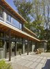 Modern home with Outdoor, Concrete Fences, Wall, Back Yard, Trees, Large Patio, Porch, Deck, Pavers Patio, Porch, Deck, and Stone Patio, Porch, Deck. Overhangs and canopies provide shade during the summer while letting sunlight penetrate to the deep interior during the winter. Photo 11 of Wallingford Passive Solar House