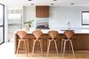 The 260 sq. ft. custom kitchen, which allows for views of the large backyard, features rich walnut wood cabinetry that is contrasted by crisp white quartz countertops and a back-painted glass and stainless steel backsplash. Photo of Ravine House modern home
