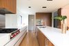 The design of the kitchen is unique in that is has no upper cabinets, and features drawers all throughout the bottom cabinetry – a feature not typically found in residential kitchen designs. Photo 3 of Ravine House modern home