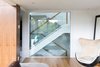 Beyond the custom glass wall in the family room is an open riser oak staircase, with glass guards and a wood handrail. Photo 8 of Ravine House modern home