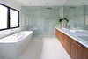 The master ensuite features the same material pallet of the kitchen that is carried throughout the whole house. Photo 10 of Ravine House modern home