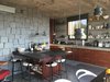 Modern home with Kitchen, Wine Cooler, Microwave, Refrigerator, Accent Lighting, Concrete Floor, Drop In Sink, Concrete Counter, Dishwasher, Ceiling Lighting, Pendant Lighting, Cooktops, Wood Cabinet, Open Cabinet, Range Hood, and Stone Slab Backsplashe. Kitchen Photo 5 of Casa Sienna