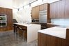 Modern home with Kitchen, Engineered Quartz Counter, Wood Cabinet, Concrete Floor, Ceiling Lighting, Glass Tile Backsplashe, Accent Lighting, Wall Oven, Refrigerator, Microwave, Cooktops, and Undermount Sink. Walnut Kitchen Cabinets by AvenueTwo, Caesarstone Countertops, Jenn-Air Appliances Photo of The Huff Residence