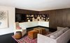 Modern home with Living Room, Media Cabinet, Storage, Bar, Sofa, Chair, Ceiling Lighting, and Dark Hardwood Floor. Family Room with Built-In Cabinets and Hidden Bar Photo 7 of Donner Residence