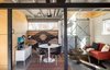 Modern home with Living Room, Coffee Tables, Sofa, Chair, Ceiling Lighting, and Concrete Floor. Living Area. Lath wall panel from salvaged lath. Original blacksmith shop barn doors. Concrete Floors. Birch wall panels. New steel supporting structure. Original brick interior - exposed. Photo 9 of Blacksmith Shop