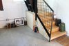 Modern home with Living Room, Bookcase, and Concrete Floor. Plywood Stair Landing with Storage Below Photo 4 of Blacksmith Shop