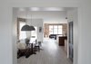 Modern home with Dining Room, Bench, Chair, Table, Pendant Lighting, and Light Hardwood Floor. View of Dining with Living Room beyond. Exposed original brick on the backwall. Photo 2 of Thole Residence