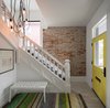 Modern home with Staircase, Wood Tread, and Wood Railing. Entryway with original staircase and exposed brick exterior wall. Photo of Thole Residence
