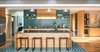 Modern home with Kitchen, Engineered Quartz Counter, Wood Cabinet, Porcelain Tile Floor, Porcelain Tile Backsplashe, Ceiling Lighting, Pendant Lighting, Refrigerator, Cooktops, and Undermount Sink. Kitchen with custom tile inlay. Custom hickory cabinets by Platform Workshop. Brass hood and cabinet wrap by Gulley Metal Services. All appliances Fisher & Paykal Photo 4 of Forest Residence