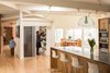 Modern home with Kitchen, Engineered Quartz Counter, Wood Cabinet, Medium Hardwood Floor, Pendant Lighting, Track Lighting, and Wall Oven. Kitchen with central pantry pod. Pantry holds things like microwave, toasters, coffee maker, etc to keep kitchen countertops uncluttered. Custom white oak cabinets by AvenueTwo:Design. Caesarstone quartz tops. Kartell pendant. Sliding doors by Sliding Door Company. Original 1960's wood floors were refinished back to like new. Brick from the original exterior of the house was uncovered and reconditioned. Photo 2 of Langley_Hawthorne Residence