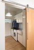 Modern home with Laundry Room, Side-by-Side, Laminate Counter, and White Cabinet. Laundry Room. Ikea build out with a custom made Melamine waterfall countertop over washer and dryer. Interior barn door is white oak slab with low luster natural finish. Photo 7 of Langley_Hawthorne Residence