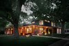 Modern home with Exterior, House Building Type, Metal Roof Material, and Brick Siding Material. Exterior in the evening with landscape and interior lighting. You can see the original fireplace extending up through the original house and becoming the fireplace in the master suite of the new addition. Photo 17 of Richthofen Residence