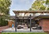 Modern home with Outdoor, Back Yard, Trees, Stone Patio, Porch, Deck, Concrete Patio, Porch, Deck, and Horizontal Fences, Wall. Patio addition from backyard. Slightly raised patio level with low trellis structure aligning to original roof heights. Photo 16 of Richthofen Residence