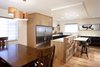 Modern home with Kitchen, Medium Hardwood Floor, Engineered Quartz Counter, Wood Cabinet, Stone Slab Backsplashe, Ceiling Lighting, Refrigerator, and Undermount Sink. Kitchen from dining room area. Photo of Pletcher Kitchen