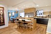 Modern home with Kitchen, Engineered Quartz Counter, Wood Cabinet, Medium Hardwood Floor, Stone Slab Backsplashe, Ceiling Lighting, Refrigerator, and Undermount Sink. Kitchen and dining area overall. Custom artwork in bar area by Tandi Venter. Cabinets are a mix of Ikea lowers with custom white oak pieces by AvenueTwo:Design Photo 2 of Pletcher Kitchen