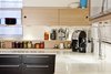 Modern home with Kitchen, Engineered Quartz Counter, Wood Cabinet, Medium Hardwood Floor, Stone Slab Backsplashe, and Undermount Sink. Custom uppers and floating shelving by AvenueTwo:Design Photo 3 of Pletcher Kitchen