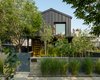 Modern home with Exterior, House Building Type, Metal Roof Material, Metal Siding Material, and Gable RoofLine. Exterior Front of House with Board Form Landscape Walls Photo 4 of Lawrence Street Residence